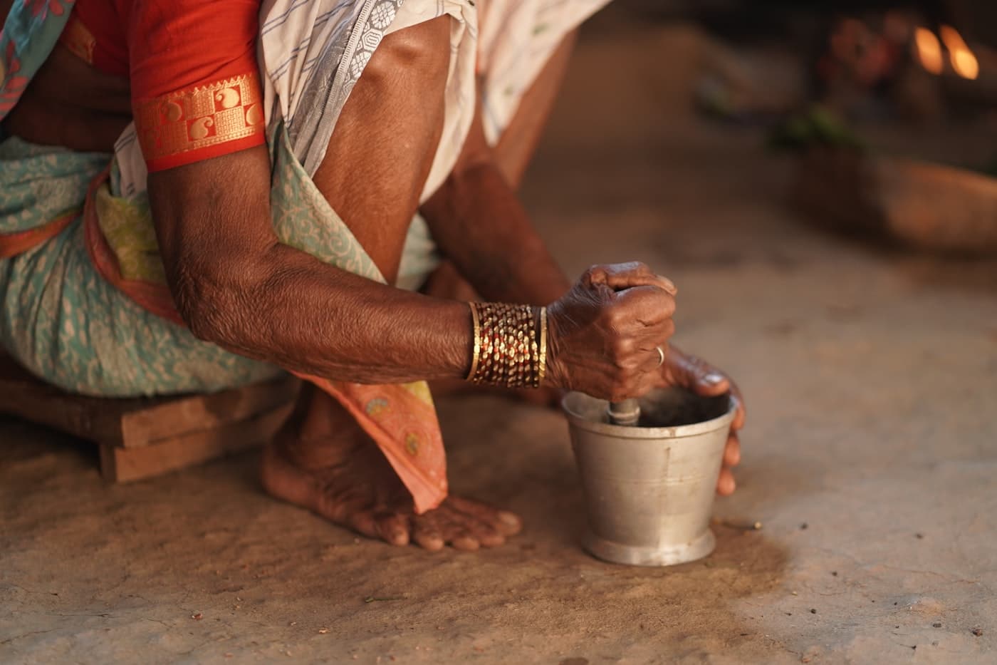 শিলপাটায় হাতে মসলা বাটছেন এক কারিগর